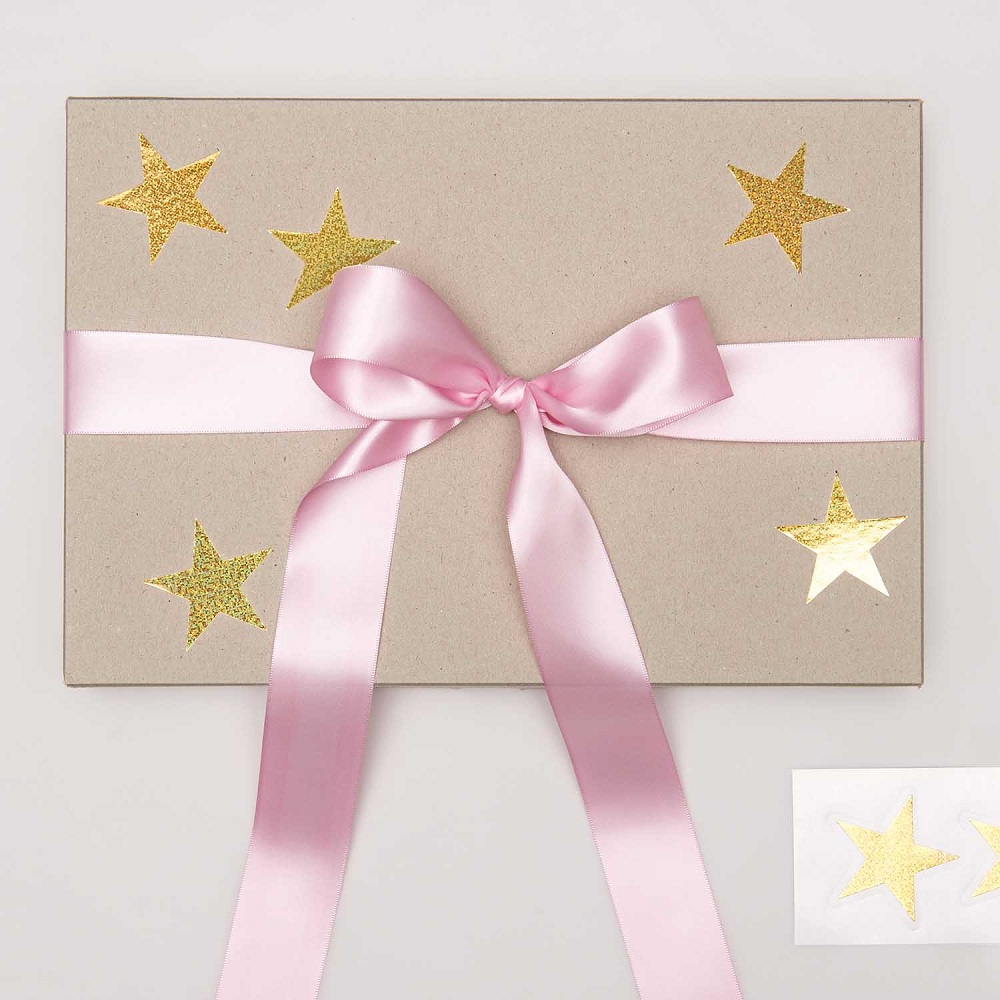 300143_AW_1 Geschenkbox, rechteckig, beige, goldene Sterne, rosafarbene Schleife, flache Maße, glatte Oberfläche, zusätzliche Aufkleber.