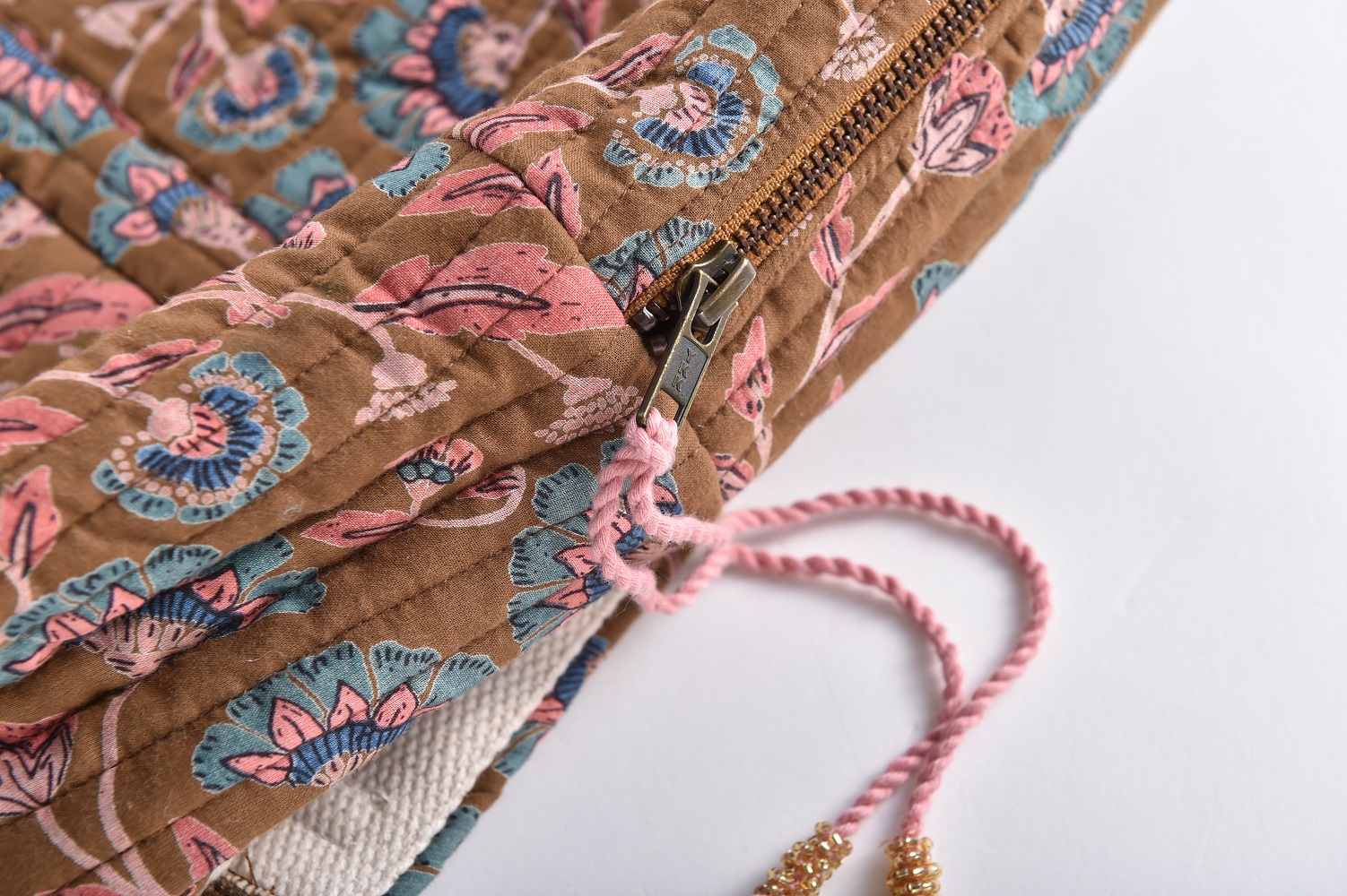 Girls-Backpack-Arti-BronzeFolkFlowers-9 Kissenbezug, Stoff braun, florales Muster in Rosa und Blau, Reißverschluss, rosa Kordel mit goldfarbenen Perlen.