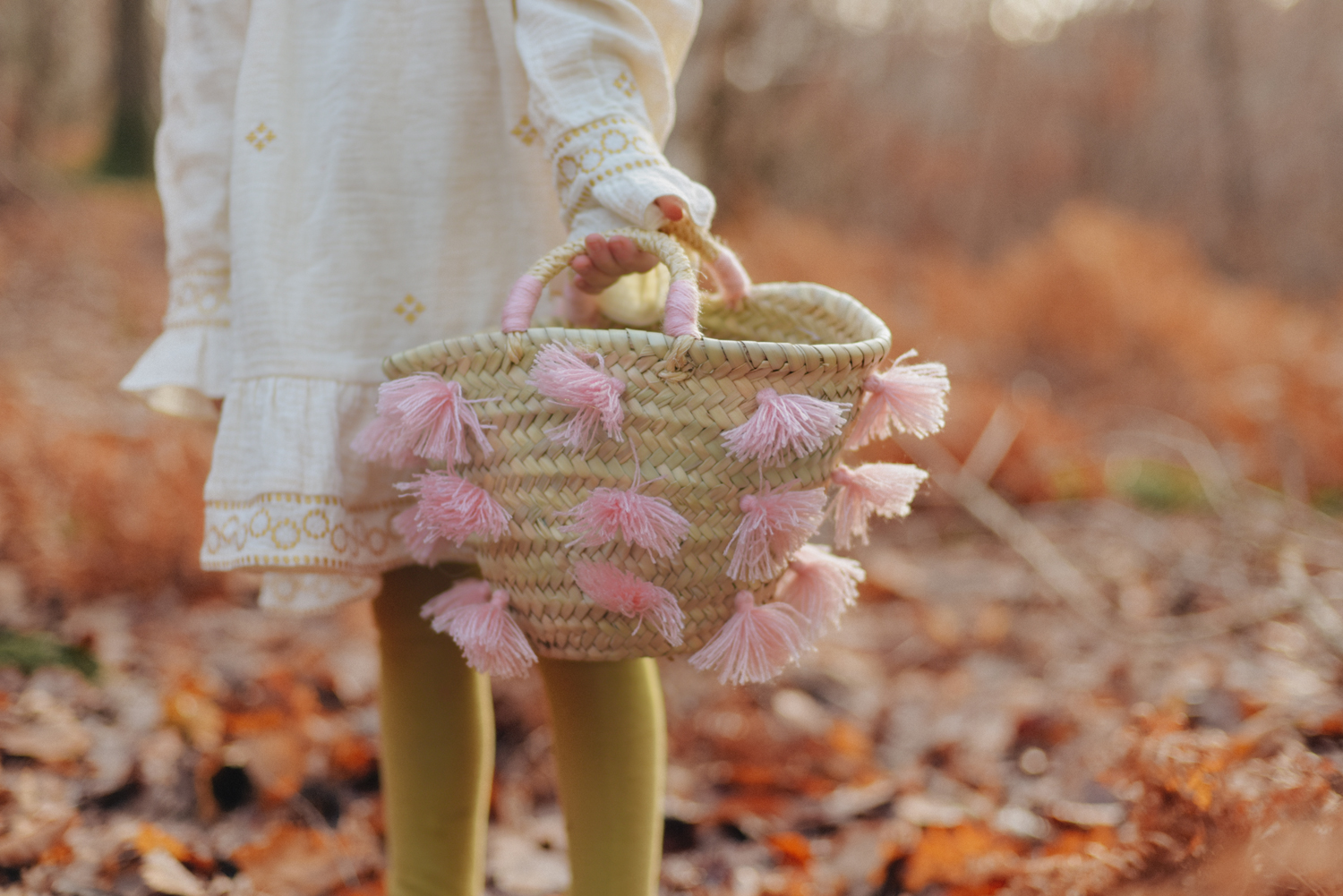 SKOVIA_CREAM_4 Korbtasche, naturfarben, rosa Quasten, geflochtene Struktur, zwei Griffe.