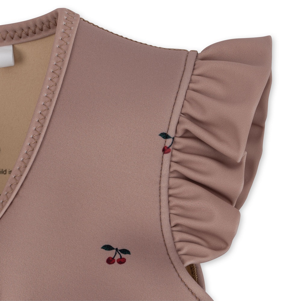 Rosa ärmelloses Oberteil, Rüschen an den Schultern, kleines Kirschmotiv.