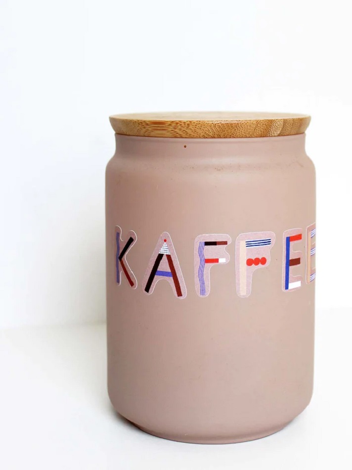 ABC_Sticker_Kaffee_700x Dosenbehälter; beige Farbe, bunte Buchstaben "KAFFEE", runder Holzdeckel.