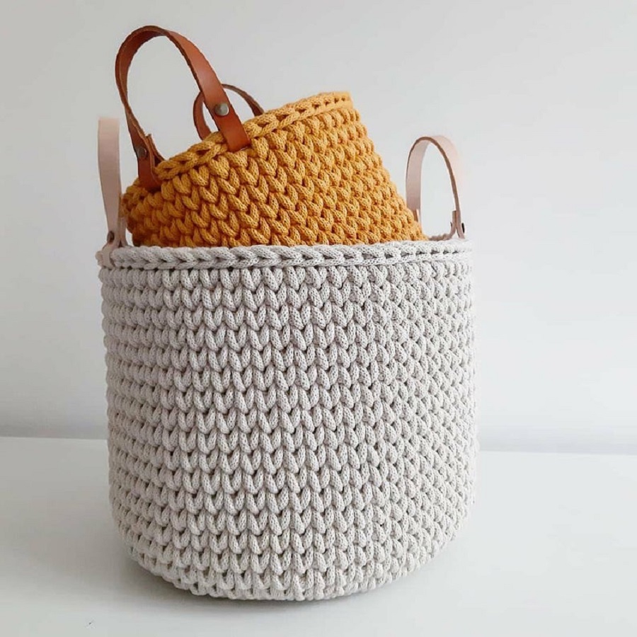 il_794xN-2841537517_2y1t Zwei gestrickte Körbe; großer Korb: beige, kleiner Korb: orange; beide mit Lederriemen.