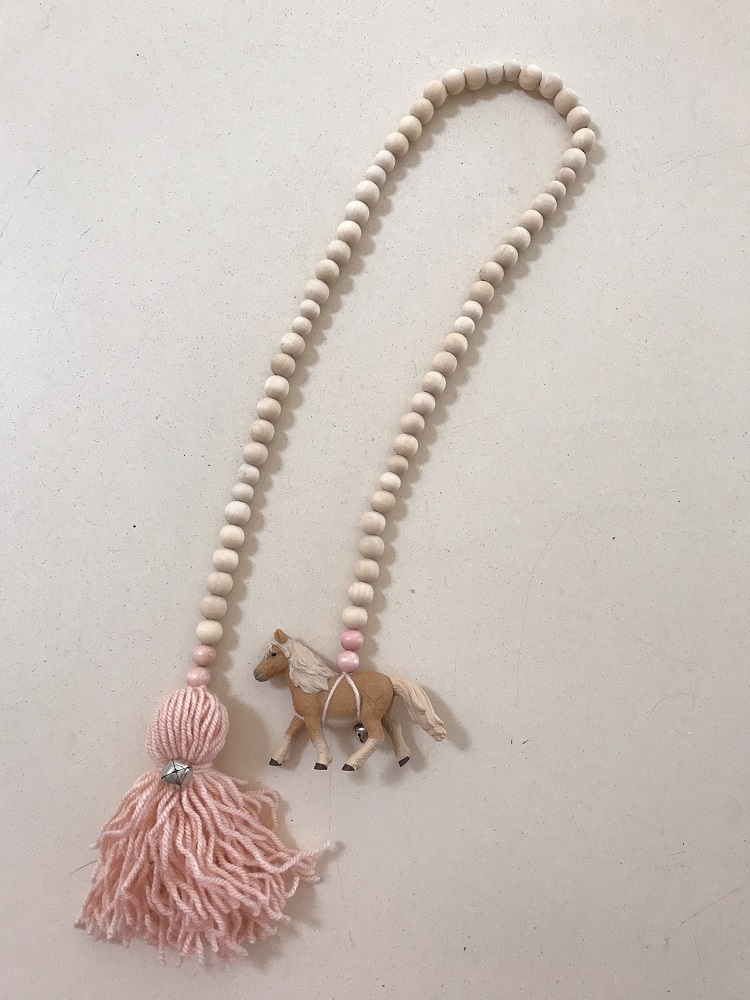 IMG_8089 Kinderwagenkette aus Holzperlen, cremefarben, mit rosa und beigen Details; Anhänger mit Pferdefigur, rosa Quaste.