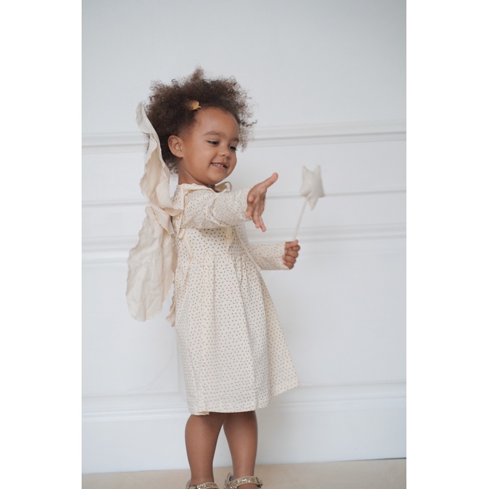 1024x1024-0453cf931cce7c332f4b379e354923f6 Kleidung für Kinder, cremefarbenes Kleid mit Muster, lange Ärmel, Schleifen und Flügel auf dem Rücken, kleines Mädchen hält Zauberstab mit Stern.