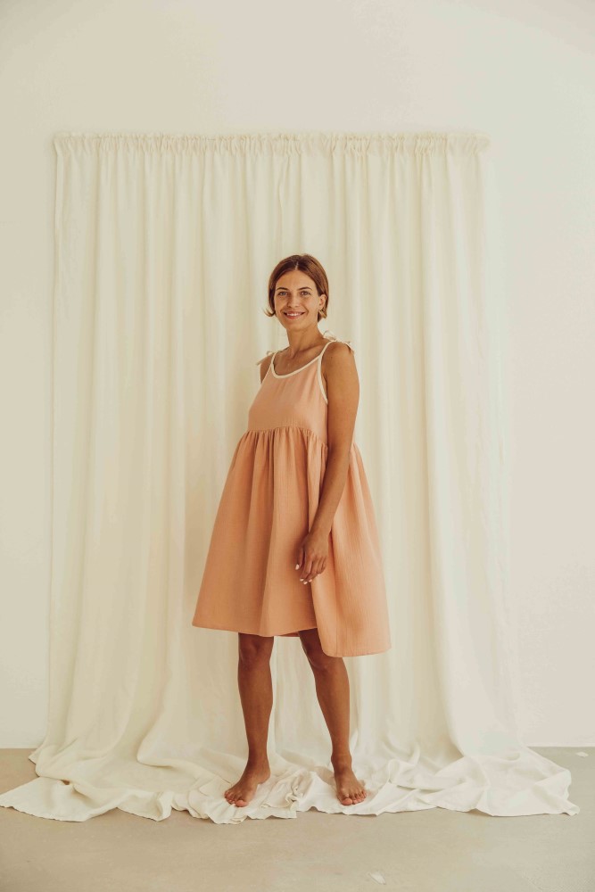 liss23_076_W_louisa-dress_peach_4 Damenkleid, ärmellos, rosa, A-Linie, knielang, leichter Stoff, weiße Trägerdetails.