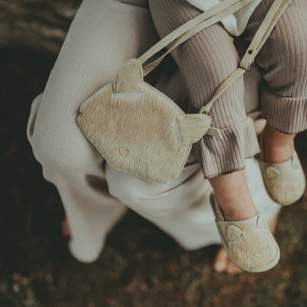 5002003_CH157_2 Kinderhandtasche und Schuhe, beige mit Katzenmotiv, Ohren-Detail an Tasche, weiche Textur, passend zu gerippten braunen Leggings.