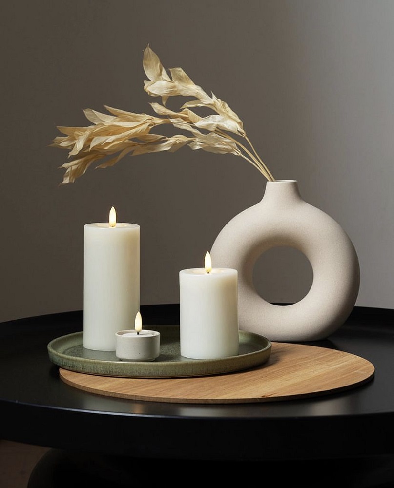 IMG_8572 Weiße Kerzen in verschiedenen Größen, rundes grünes Tablett, beige Vase mit Loch, getrocknete Gräser.