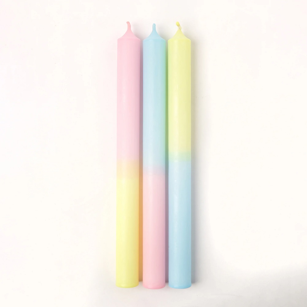 S8_1024x1024-2x Drei lange Stabkerzen, pastellfarben; links rosa-gelb, Mitte blau-gelb, rechts gelb-blau; glatte Oberfläche; minimalistische Gestaltung.