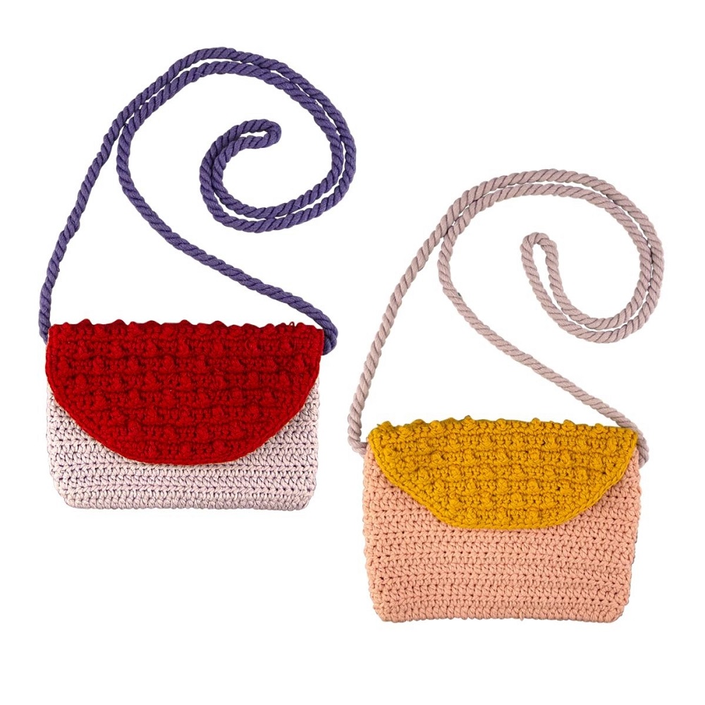 9511260-Handtasche-sortiert-1 Zwei gehäkelte Umhängetaschen, links rot-lila, rechts gelb-rosa, mit langen, gedrehten Trageriemen.