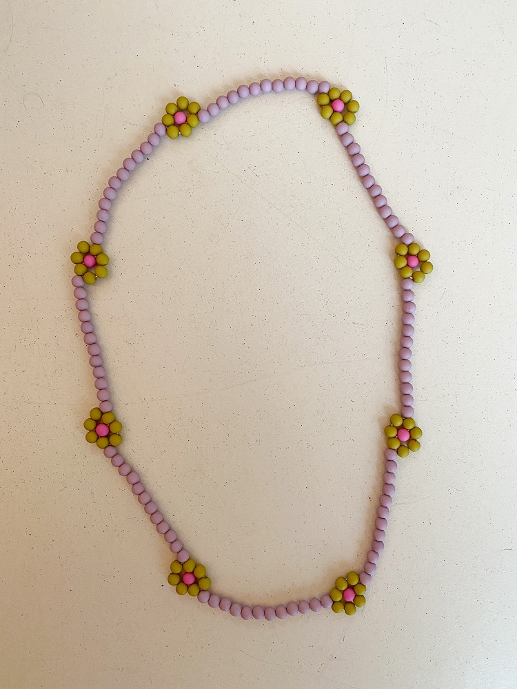 IMG_4972 Halskette, lila Perlen, Blumenmuster aus gelben und pinken Perlen, schlichte Gestaltung.