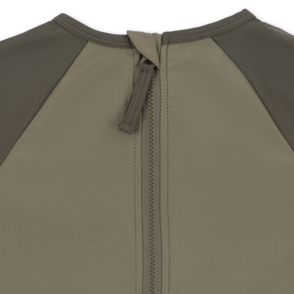 KS4621-ASTER-SWIM-BLOUSE-DINO-OVERLAND-TREK-Extra-2 Kleidungsstück, Zweifarbig, Reißverschluss hinten, heller Khaki-Ton, dunklere Schulterfarbe, mittiger Zipper, Nackenband.