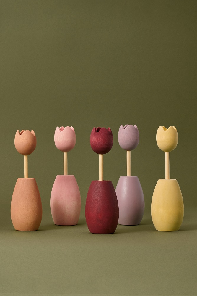 200904_Raduga_Grez_campaign5274 Holzblumen, fünf Stück, Tulpenform, matte Farben: orange, rosa, rot, lila, gelb, natürliche Holzstiele, dekorativ, stehende Anordnung auf grünem Hintergrund.