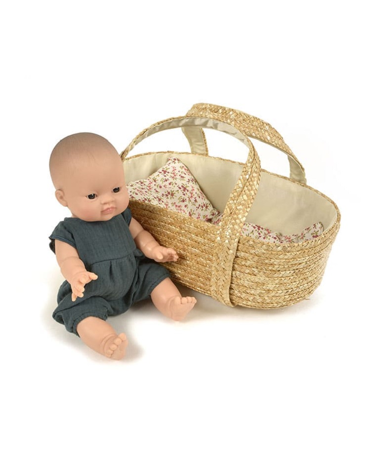 couffin-poupees-tresse-35cm-minikane-astrup Babypuppe, dunkelgrauer Strampler; Korb aus geflochtenem Stroh; Innenfutter beige mit roten Blumenmuster.