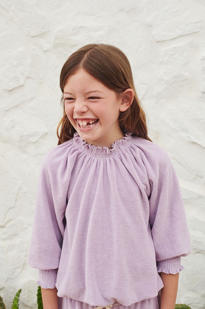 SS22_016_Terry-Smocked-Blouse_lavender_closeup Mädchenpullover, lavendelfarben, langärmlig, geraffter Kragen.