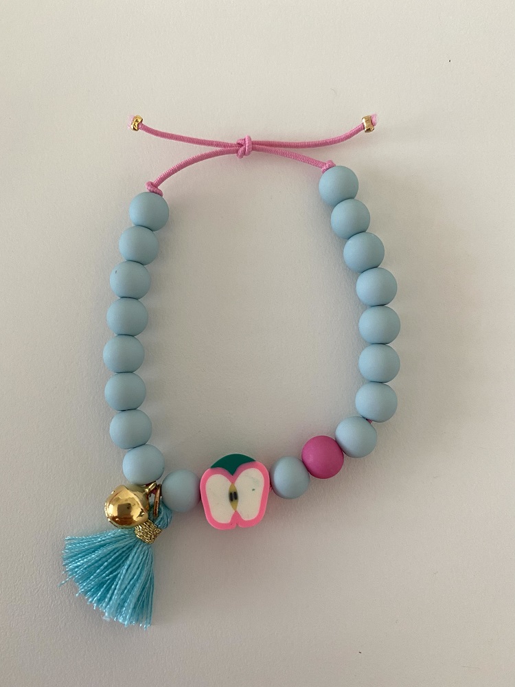 IMG_7975 Armband aus blauen Kugeln, pinkem Zugband, Apfel-Design, goldene Glocke, blauer Quast, pinke und blaue Verzierung.