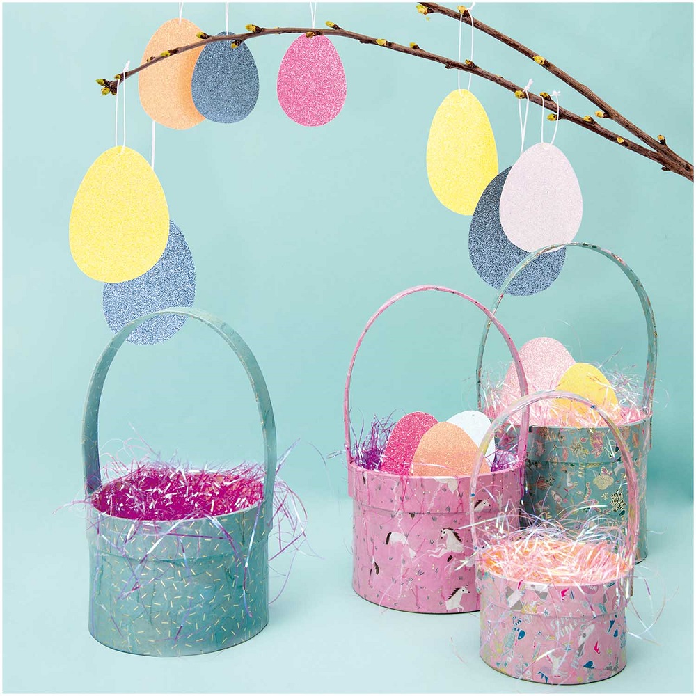 99001-50-63_M_1 Osterkörbe, verschiedene Pastellfarben, glitzernde Eier aus Papier, gemustert, Henkeltaschen, gefüllt mit buntem Kunstgras, Hintergrund hellblau.
