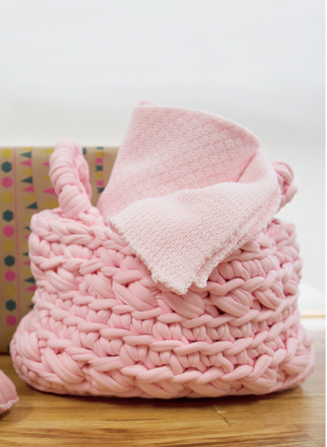 Bildschirmfoto-2017-01-19-um-17-00-11 Gestrickter Korb, rosa, grobe Maschen, enthält rosa Handtuch, Strukturmuster, Holzuntergrund.