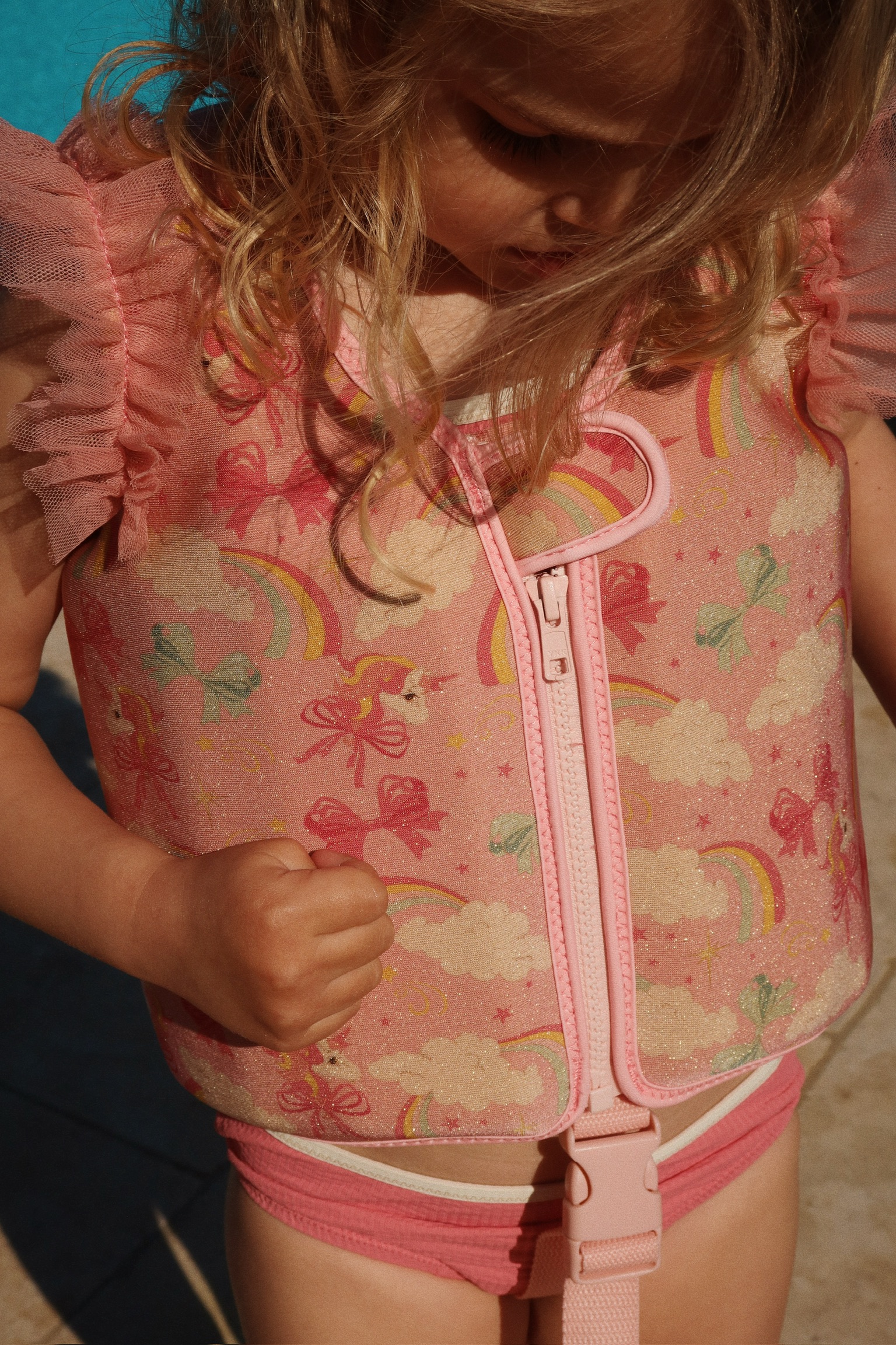 Kinderschwimmweste, rosa, Einhörner, Regenbogen, Schleifen, Wolken, Glitzer, Reißverschluss vorne, Rüschen an den Schultern.