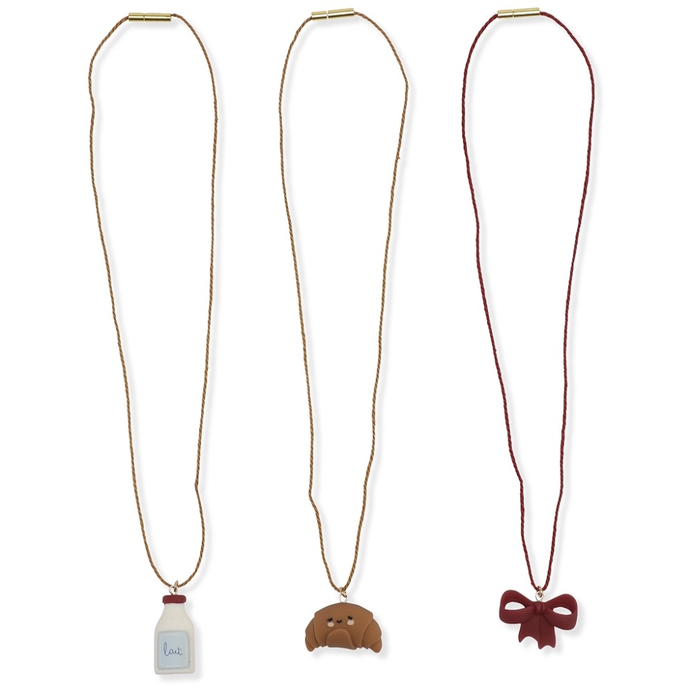 1024x1024-2acda30bfaafade837698831e92ce613 Drei Halsketten, goldene Schnüre; Anhänger: weiße Milchflasche mit "lait"-Aufdruck, braunes Croissant, bordeauxrote Schleife.