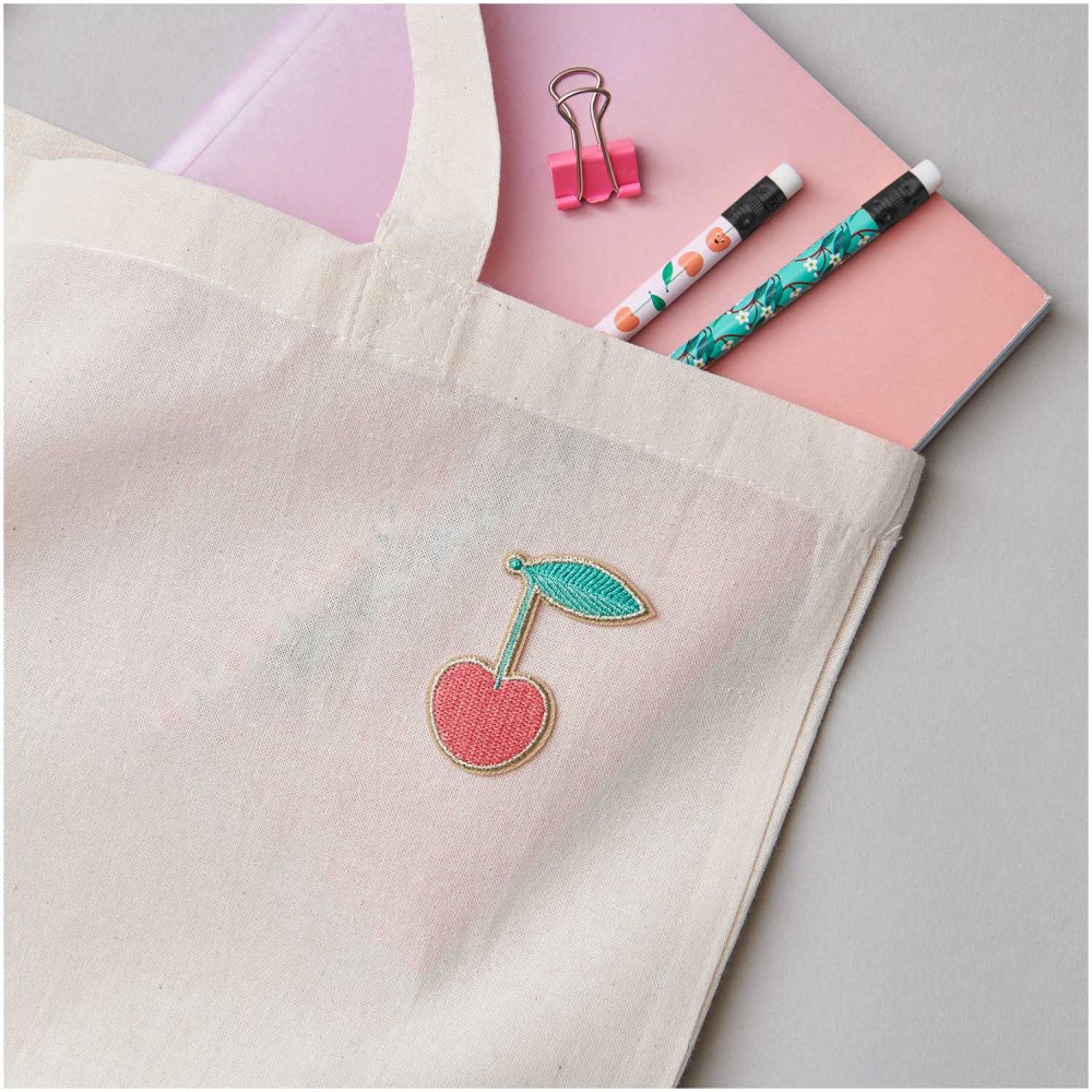 280082_aw_1 Stofftasche, naturfarben, Kirschenmotiv, Aufnäher, enthält rosa Notizbuch, zwei Bleistifte mit Muster.