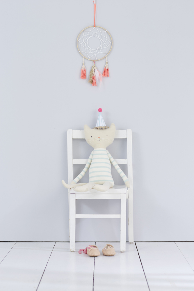 20161005_MERIMERI_03_DREAMCATCHER_009_E1 Kuscheltiertier Katze, beige, gestreifter Pullover in Hellblau und Weiß, Partyhut rosa-weiß, sitzt auf weißem Stuhl, daneben Ballettschuhe aus Stoff, heller Boden, schlichter Hintergrund.