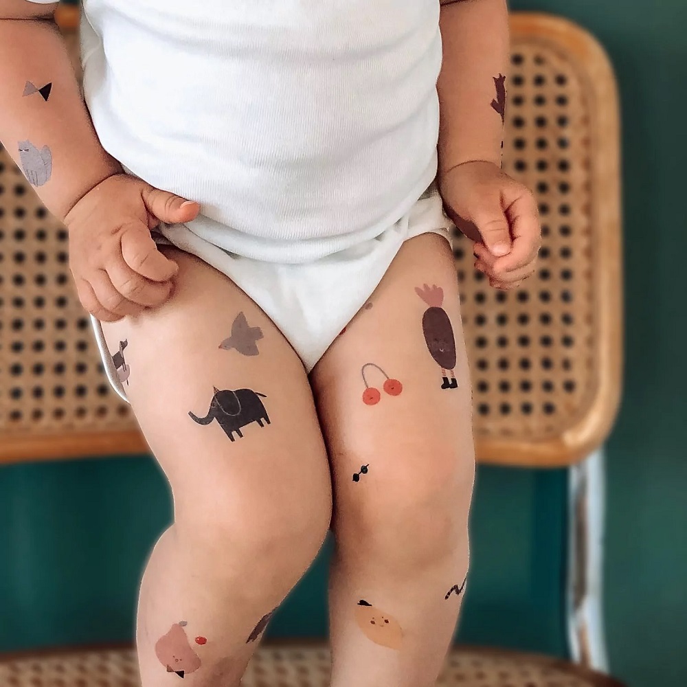 nuukk_Kids_Tattoos_Elephant Babybody weiß, temporäre Tattoos auf Kinderbeinen, Motive: Elefant, Obst, Tierfiguren, geometrische Formen.