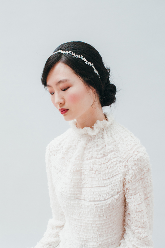 50UA1_model_raw Haarband, silbern mit Kristallen, elegant; weißes Kleid mit Rüschen, hochgeschnittener Kragen.