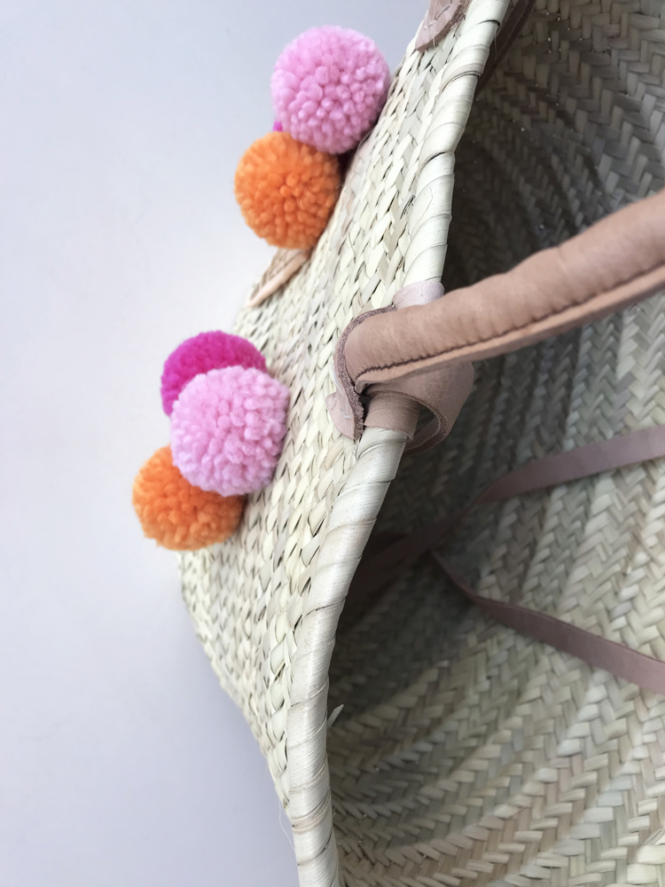 IMG_2906 Weidenkorb, naturfarben, Henkel aus Leder, bunte Pompons in Rosa und Orange.