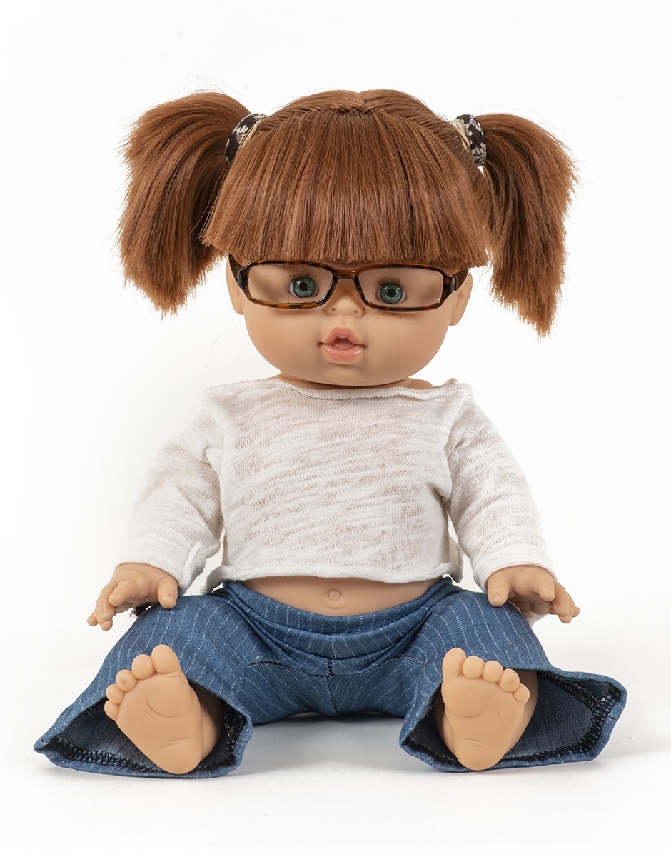 minikane-lunettes-pour-poupees-34cm-meryl3 Puppe, braune Haare, Zöpfe, Brille, helles Oberteil, blaue Hose.