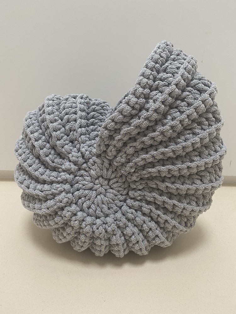 IMG_1672 Gehäkeltes Kissen, grau, muschelförmig, dicke Strickstruktur.