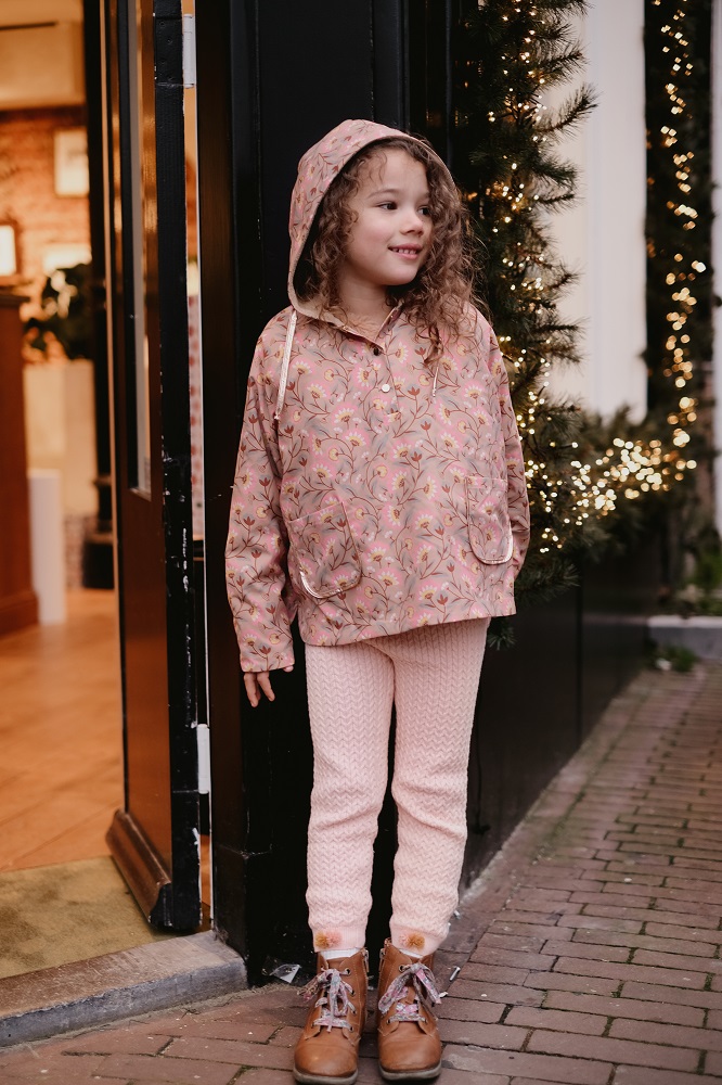 Girls-Raincoat-Mara-KhakiFolkFlowers-4 Mädchenjacke mit Kapuze, rosa, florales Muster; passende rosa Hose; braune Stiefel mit Schnürung; Kordelzüge an Kapuze.