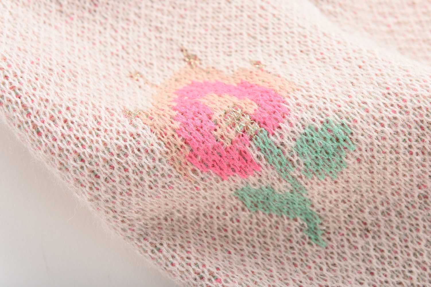 babypantshuachocream8 Beiges Strickgewebe, rosa Blumenaufdruck, grüne Blätter, florales Muster.