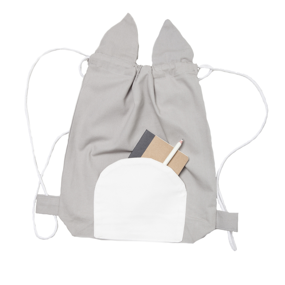stringbag-cat-1 Grauer Stoffrucksack mit Kordelzug, weiße Fronttasche, zwei stoffartige Ohren, enthält Notizbuch und Bleistift.