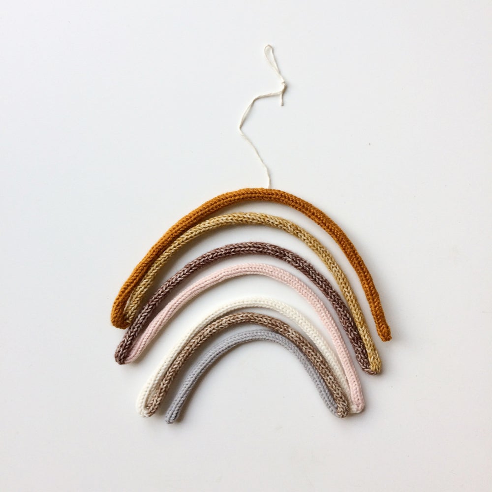 4C96D3B5-5BC7-4346-8212-F63744CF90E9 Gehäkelte Wanddeko, Regenbogenform, fünf Bögen, Farben: senf, beige, braun, rosa, weiß; Material: Baumwolle, Aufhängeschlaufe.
