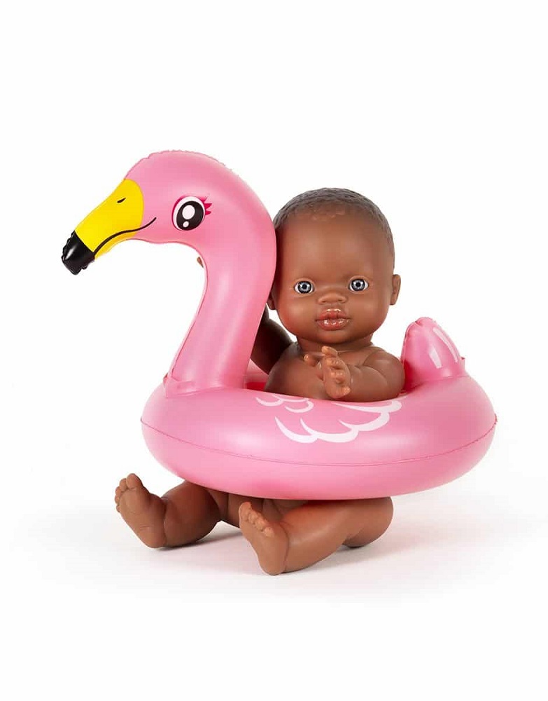 bouee-gordis Puppe, braune Haut, rosa aufblasbarer Schwimmring, Flamingo-Design, gelber Schnabel, fröhlicher Ausdruck.