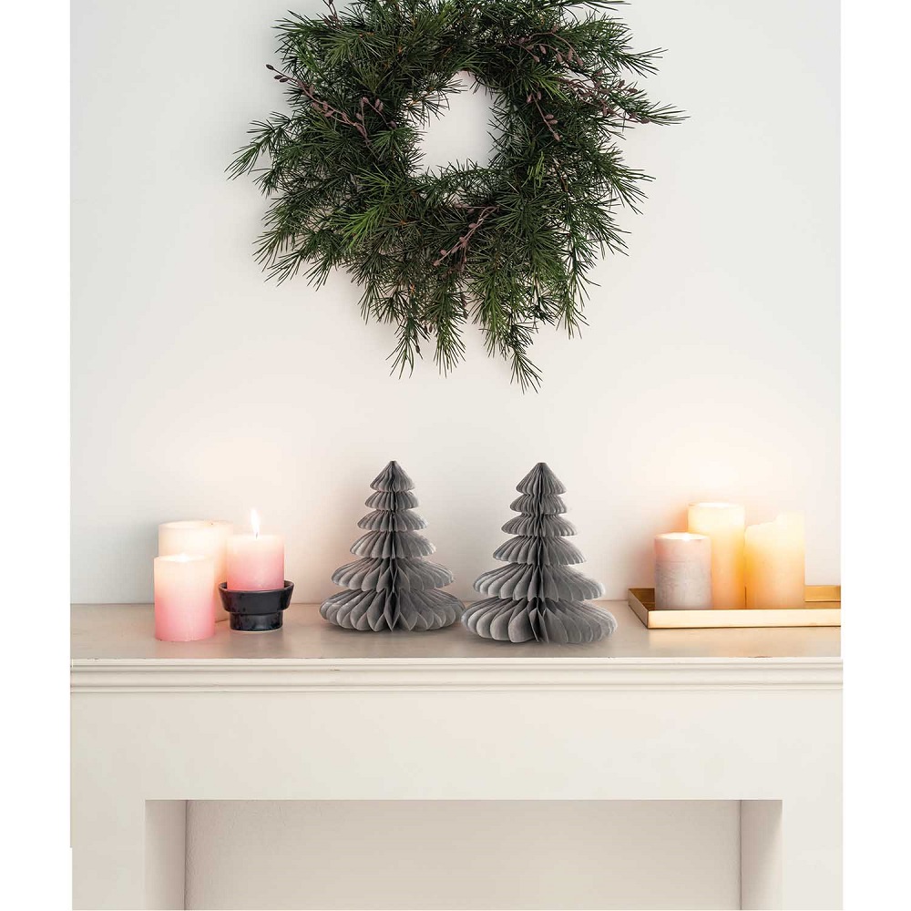 99001-69-14_aw_3 Papier-Weihnachtsbäume, grau, auf Kaminsims; daneben mehrere Stumpenkerzen in verschiedenen Größen und Farben; darüber grüner Kranz an der Wand.