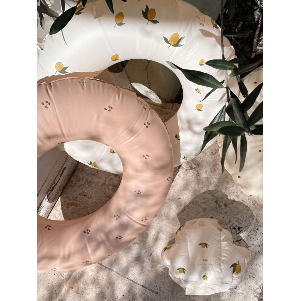 1024x1024-b1fcdca094597165d31c0a4c49fb5bde Schwimmringe und Schwimmwindeln; creme mit Zitronenmotiv, rosa mit kleinem Blumenmuster; weiche Pastellfarben; Oberflächen glatt; Schatten von Blättern.