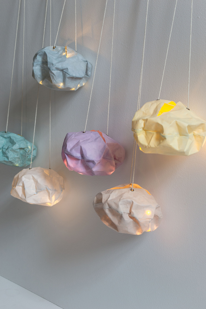 DSC_0531 Hängelampen aus Papier, wolkenförmig, Farben: Blau, Lila, Gelb, Grün, Creme; Lichtdurchlässig, unregelmäßige Struktur, an weißen Kabeln befestigt.