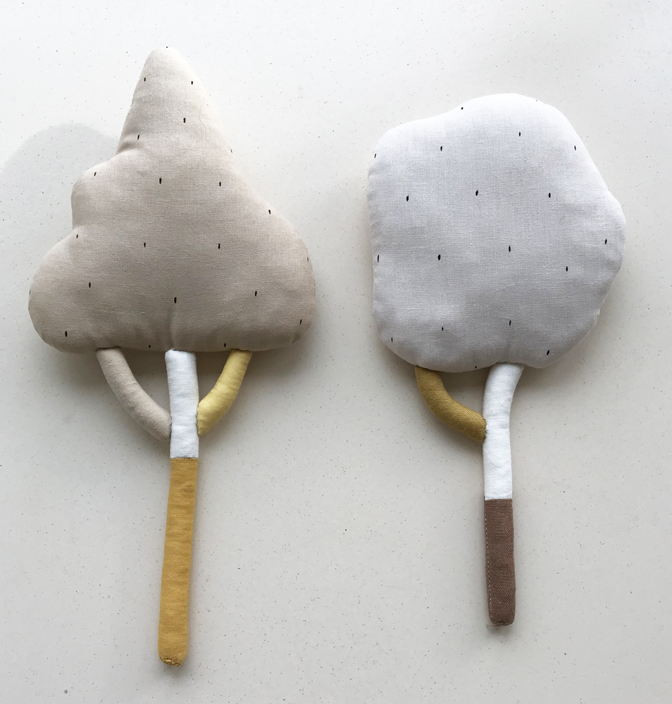 IMG_1344 Stoffkissen in Form von zwei Bäumen, linkes Kissen beige, rechtes Kissen hellgrau, beide mit kleinen schwarzen Punkten, Stiel in Gelb und Weiß.