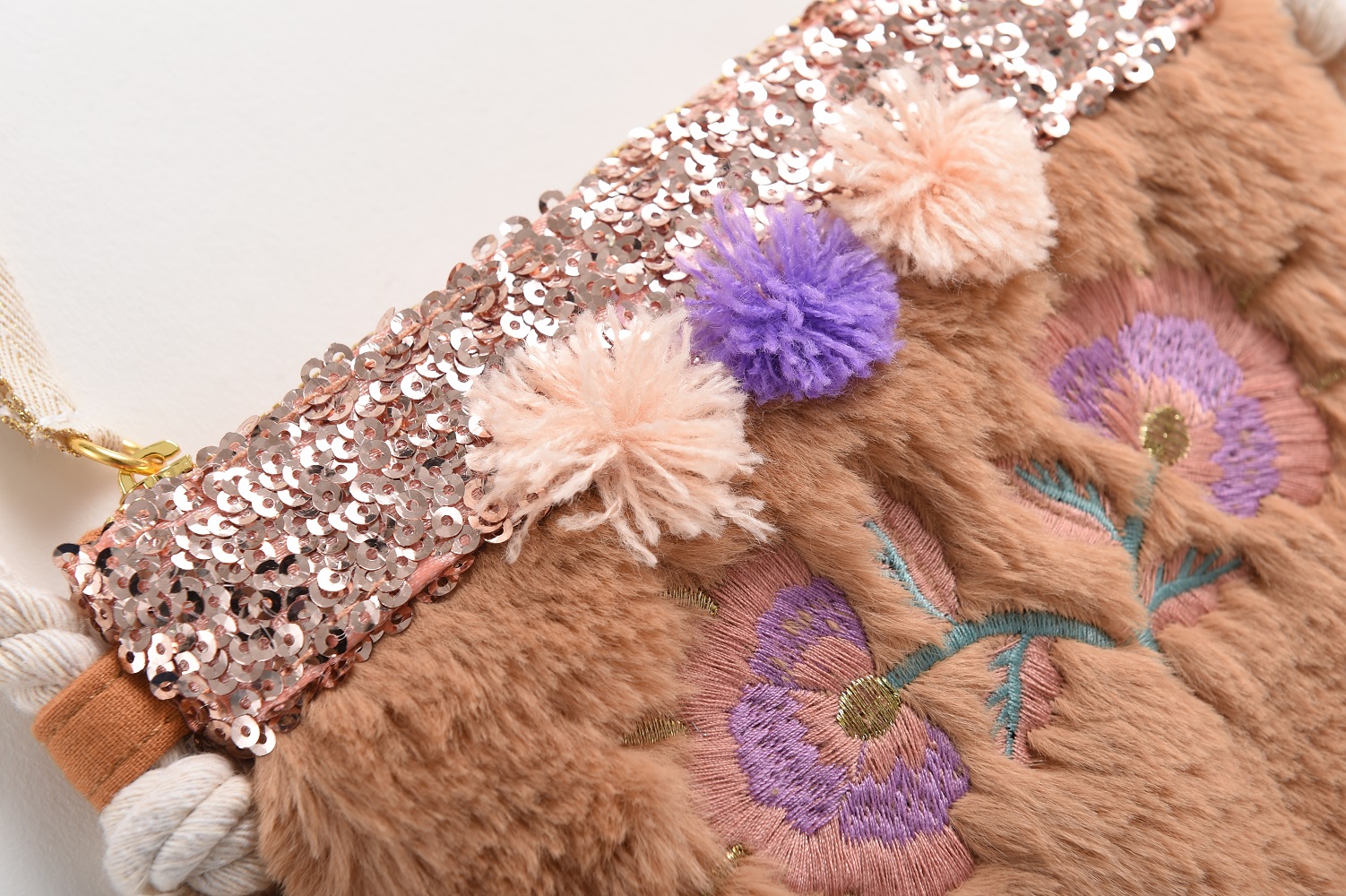 kidsbagazucenanuts7 Handtasche aus Kunstfell, beige, Paillettenbesatz oben, rosa Pailletten, Pompons in Lila und Hellrosa, florale Stickerei in Lila und Grün, Seilgriff, dekorative Troddeln.