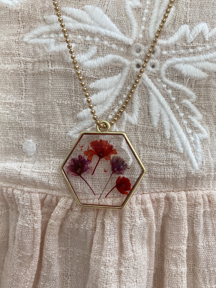 IMG_2612qRnSmyN6kGCx2 Kette, goldene Perlenkette, sechseckiger Anhänger, transparente Fassung, bunte eingegossene Blumen in Rot, Pink und Violett.