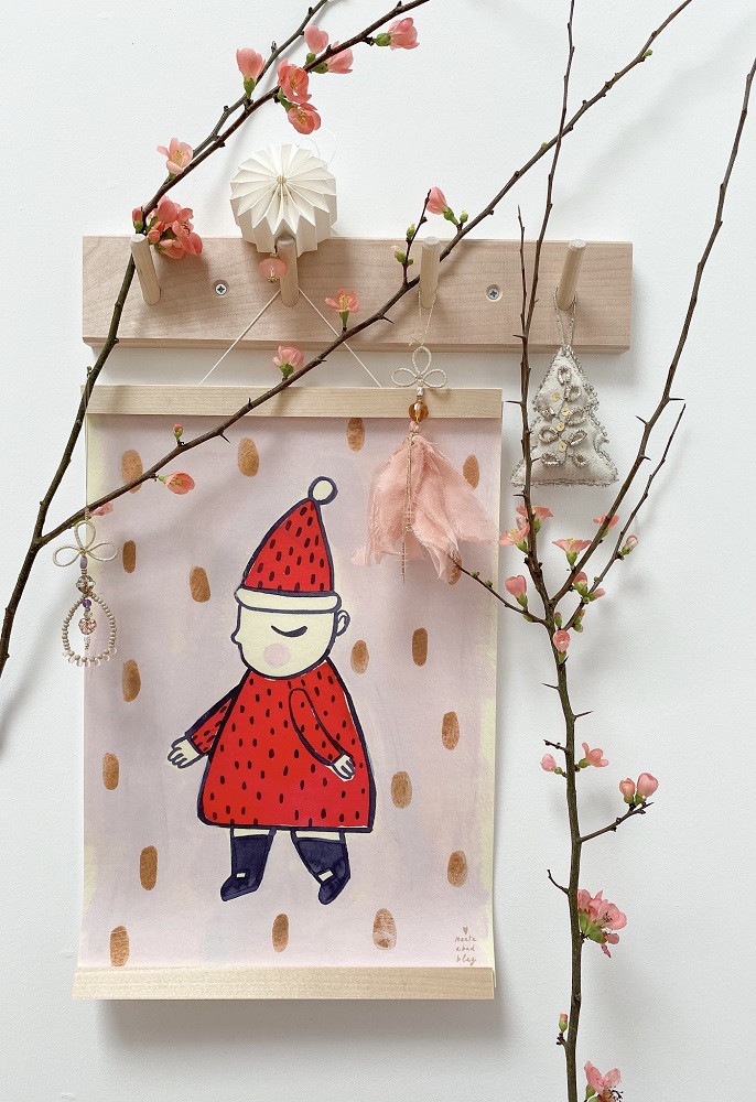 IMG_0994 Illustration, Kind mit rotem Mantel und Mütze, beiger Hintergrund mit braunen Punkten, Holzleiste, Zweige mit rosa Blüten, hängende Deko-Objekte aus Papier und Stoff.