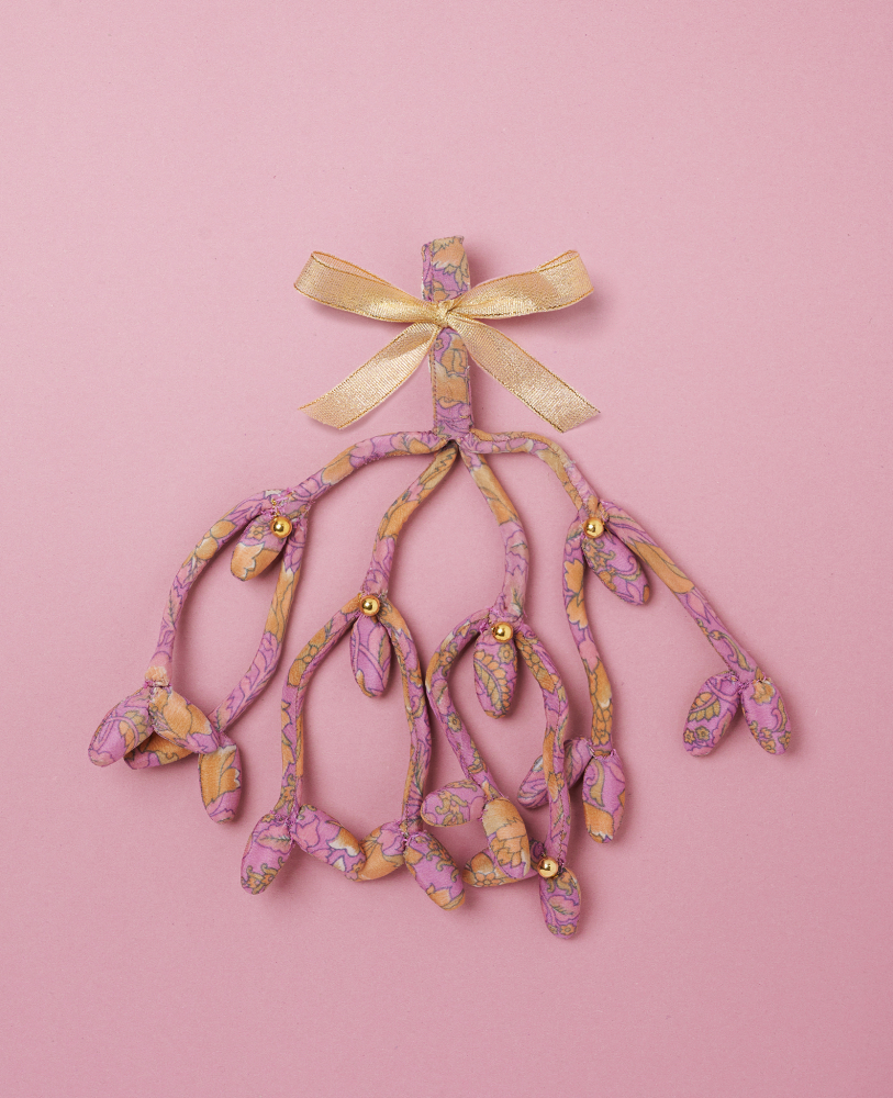 Mathilda-SILK-Mistletoe-Tropical Stoffmistelzweig, lila-gelb florales Muster, goldene Schleife, goldene Perlenverzierung, rosa Hintergrund.