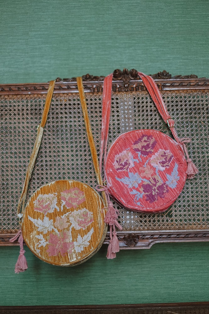 womenbagsiahoney2 Zwei runde Umhängetaschen, florales Muster; eine in Orange, eine in Rosa; Quasten an der Seite.