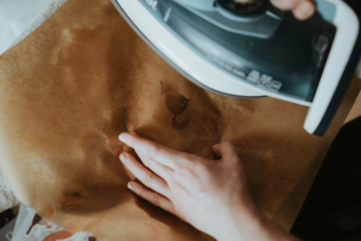 2022-02-nuuk-131-scaled Bügeleisen, Hand, braunes Wachspapier, dunkler Aufdruck eines Tieres, keine Dekoration.