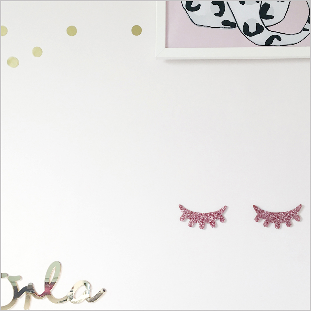 pink1 Wandtattoo rosa Glitzer-Wimpern, metallischer Schriftzug, weißer Hintergrund, goldene Punkte, gerahmtes Bild mit schwarz-weißem Muster auf rosa Hintergrund oben rechts.