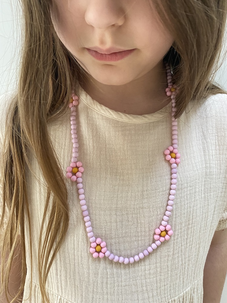 IMG_4902 Kinderkette, rosa Perlen, Blumenmuster, Blüten in Rosa und Gelb, getragen von Kind mit beigem Oberteil.