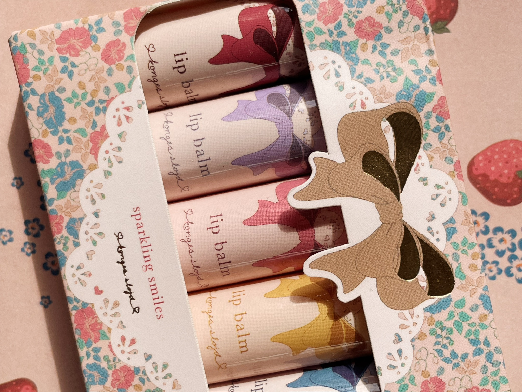 Lip Balm Set, mehrere Farben, Verpackung mit Schleifen-Design, florale Muster, Aufdruck „konges slöjd“.