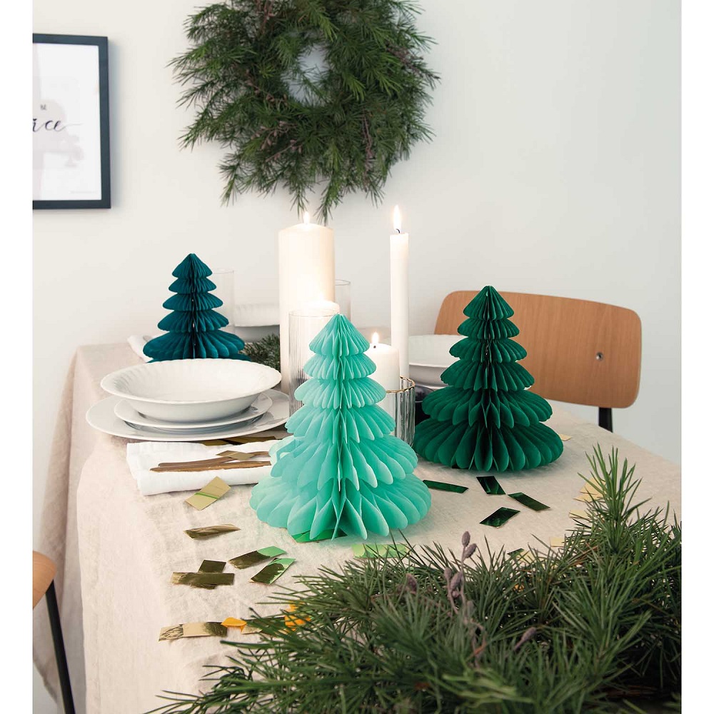 99001-69-12_aw_2 Papier-Weihnachtsbäume, türkis und dunkelgrün, auf Tisch; weiße Kerzen, weiße Teller, goldfarbenes Konfetti; Tischdecke beige.