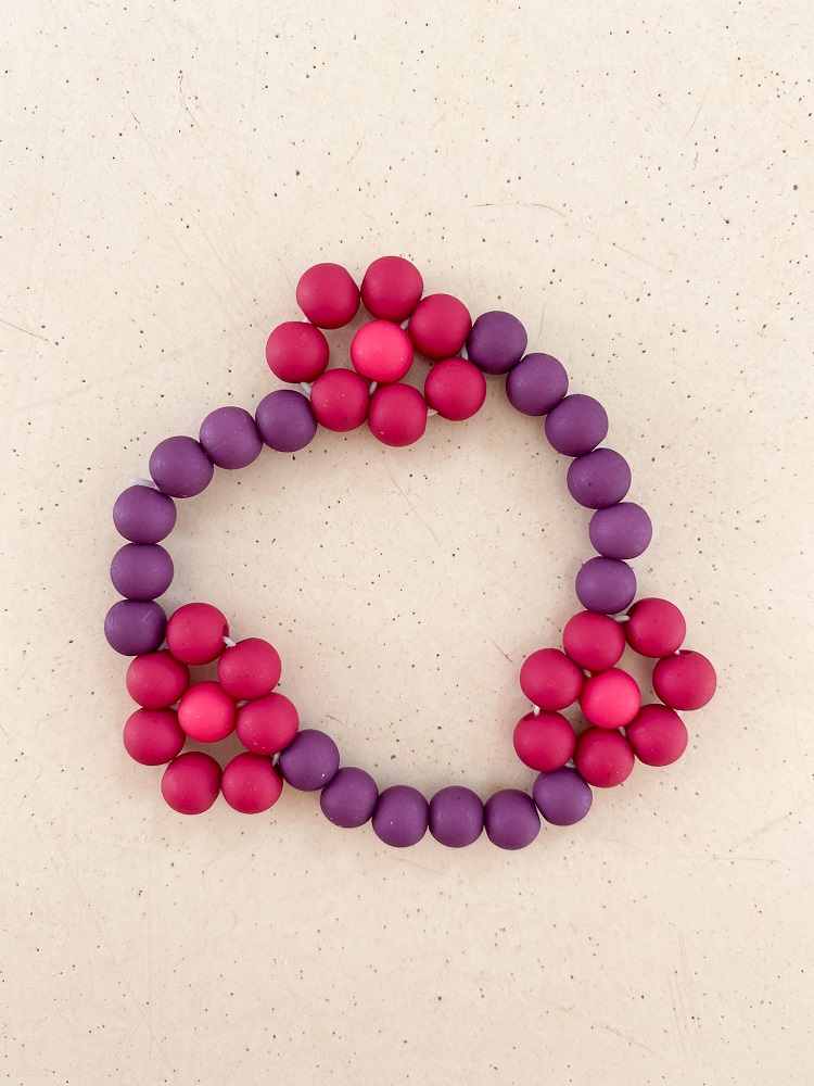 IMG_4992 Perlenarmband, lila und pink, rundliche Perlen, Blumenmuster-Design.